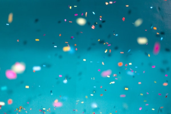 image of colored confetti with a sky blue background